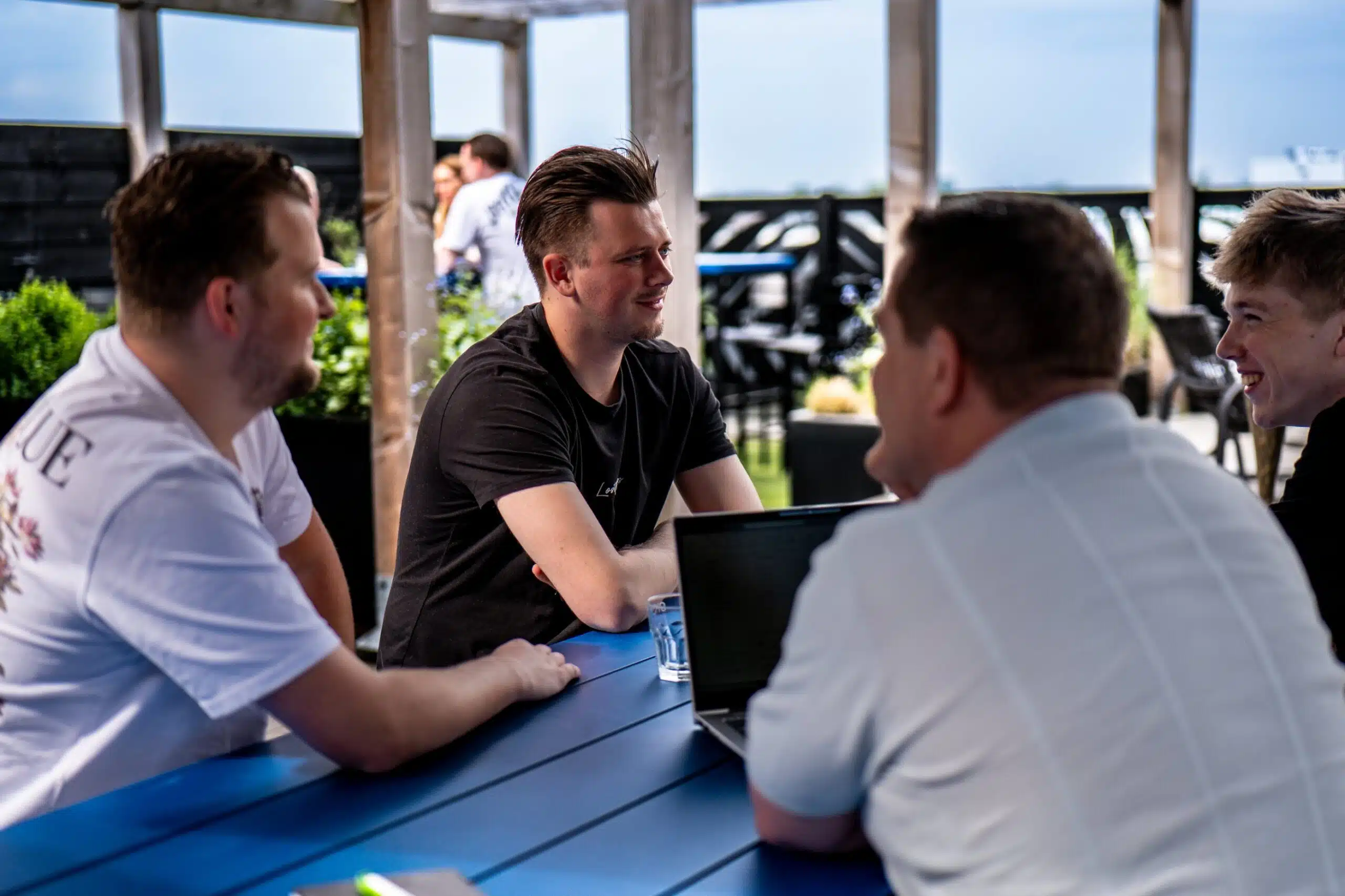 GKS-collega’s in overleg aan een buitentafel met laptop.